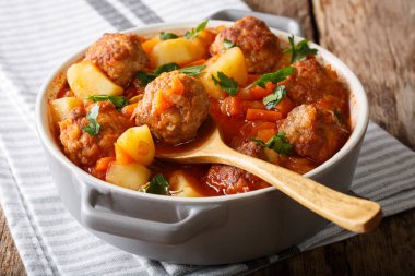 Hot stew meatball soup with vegetables in tomato sauce closeup i clipart