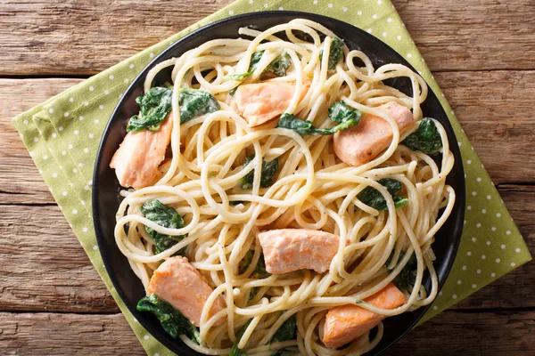 Вкусная спагетти макароны с лосося и шпината крупным планом на р — стоковое фото