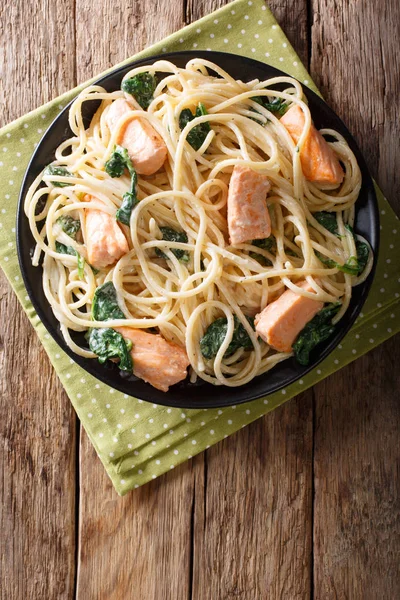 Сливочные спагетти с лососиной и шпинатом крупным планом на тарелке. Ve — стоковое фото