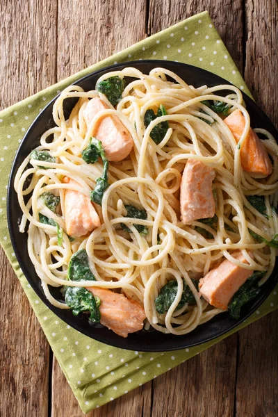 Вкусная спагетти макароны с лосося и шпината крупным планом на р — стоковое фото