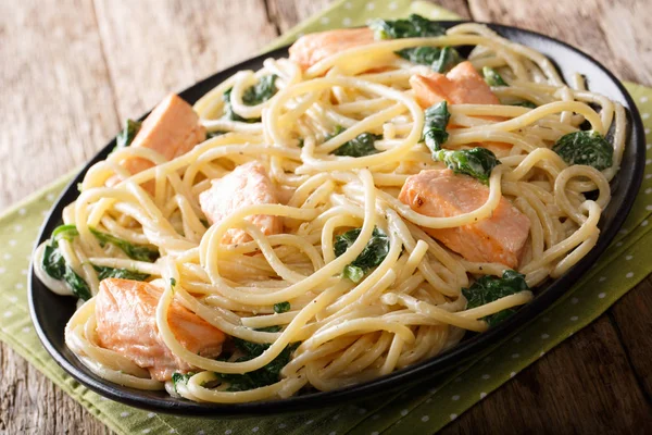 Итальянская кухня: спагетти с лососем, сливочным сыром и шпинатом — стоковое фото