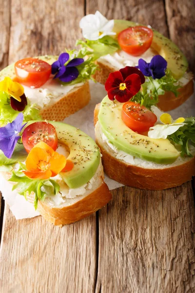 Вегетарианские открытые сэндвичи с авокадо, помидорами, съедобными цветами — стоковое фото
