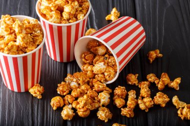 Kağıt ahşap masa kovanın içinde karamel ile lezzetli patlamış mısır bir