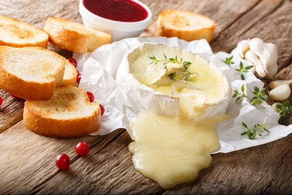 Растаявший острый камамберский сыр с чесноком, тимьяном и оливковым маслом с — стоковое фото