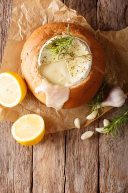 Bir somun ekmek fondü camembert peyniri yakın çekim bir tablo üzerinde erimiş. Abov gelen dikey Üstten Görünüm