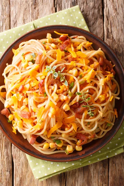 Спагетти с беконом, кукурузой и сыром Mimolette крупным планом — стоковое фото