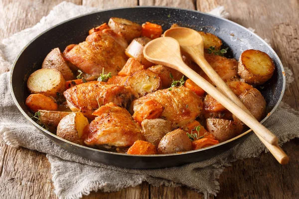 Cosce di pollo cotte con patate e carote primo piano in un pa — Foto Stock