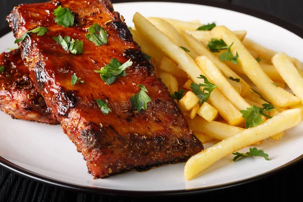 Serving barbecue short ribs with french fries close-up on a plat — Stock Photo, Image