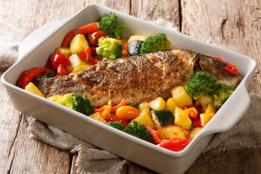 Fırında balık sazan balığı ve yaz sebzeleri. Bir fırında yakın plan.