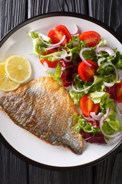 Dorado filetosu ve taze salata tabağı. dikey