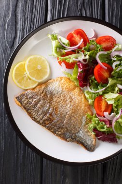 Fırında Dorado filetosu ve taze sebze salatası tabakta yakın plan.