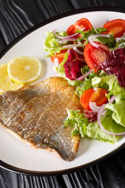 Dorado filetosu ve taze salata tabağı. dikey