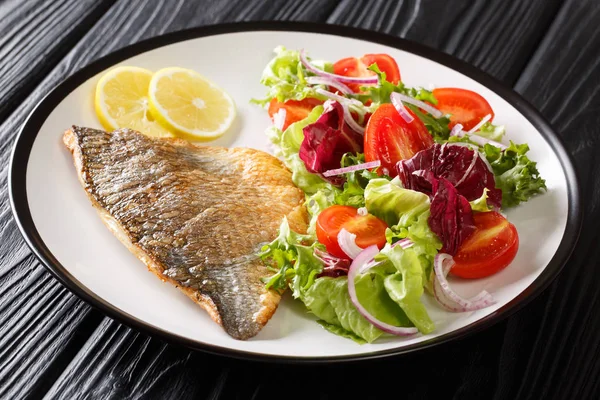 Main dish fried dorada fillet with vegetable salad close-up on a — Stock Photo, Image