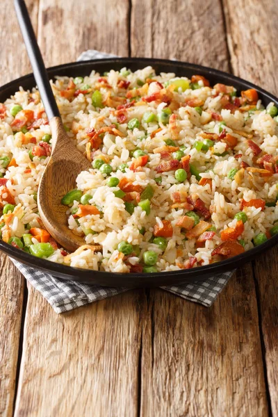 Warme rijst met wortels, groene erwten, uien en spek close-up in — Stockfoto