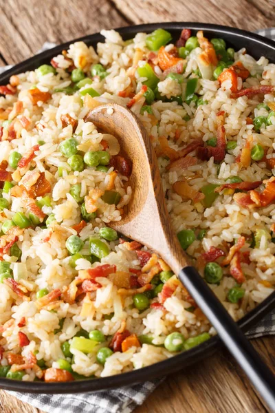 Gebakken rijst met wortelen, groene erwten, uien en spek close-up i — Stockfoto