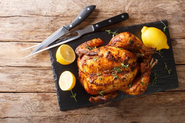 Traditional rotisserie chicken served with lemon closeup on a sl — Stock Photo, Image