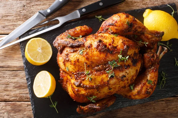 Knapperige sappige rotisserie kip close-up op een leien plank op de — Stockfoto