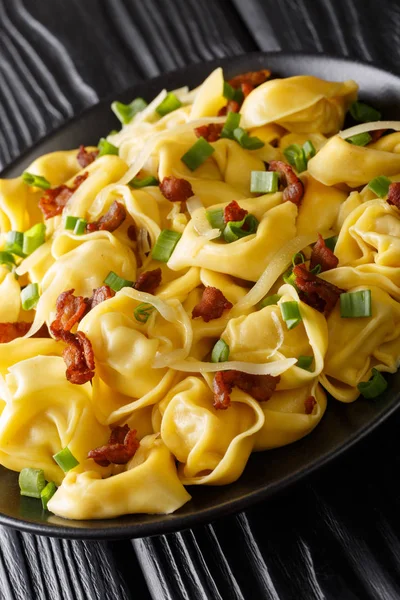 Tortelloni with bacon, cheese and green onions close-up in a pla — Stock Photo, Image
