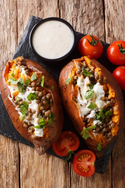Baked sweet potato stuffed with lentils and topped with sour cre — Stock Photo, Image