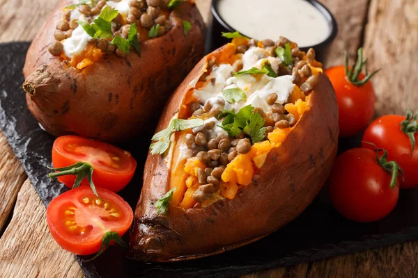 Batata-doce assada inteira com lentilhas servidas com creme azedo e — Fotografia de Stock