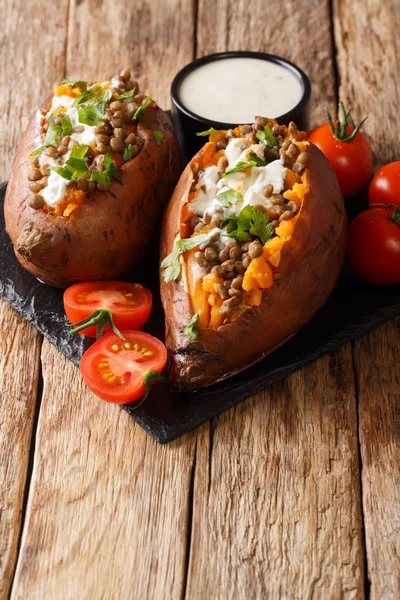 Batata doce cozida no forno saborosa com lentilhas e coberta com creme azedo — Fotografia de Stock