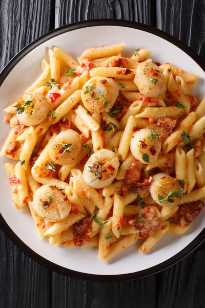Penne pasta met sint-jakobsschelpen, tomaten, kruiden en pittige saus dichtbij — Stockfoto