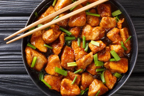 Stir fry chicken fillet in spicy sweet sauce close-up in a plate