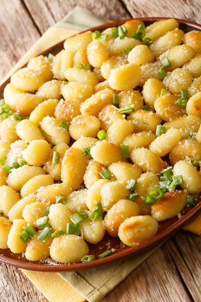 Gnocchi prăjit cu usturoi și parmezan aproape pe o farfurie. vert — Fotografie, imagine de stoc