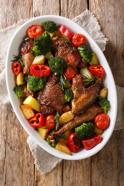 Fried pieces of chicken with vegetables and herbs close-up in a — Stock Photo, Image