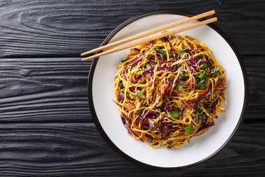 Stir-fried egg noodles with red cabbage, carrots, herbs and sesa