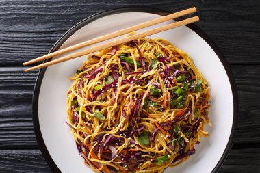 Tasty egg noodles with vegetables and sesame seeds close-up in a