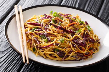 Asian style egg noodles with red cabbage, carrots, herbs and ses