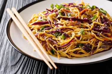 Stir-fried egg noodles with red cabbage, carrots, herbs and sesa