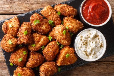 Crispy coconut chicken nuggets served with ketchup and mayonnais