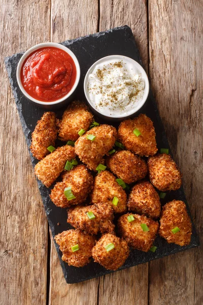 Deep-fried coconut breaded chicken with two sauces close-up on a — ストック写真