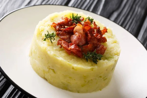 Mashed potatoes and green cabbage topped with fried bacon closeu — Stock Photo, Image