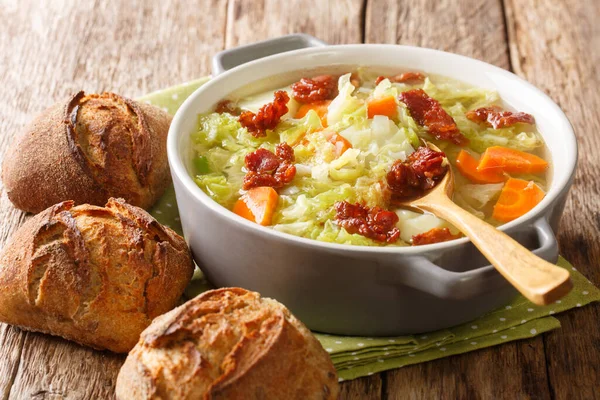 野菜のキャベツスープと揚げベーコンが添えられています。- — ストック写真