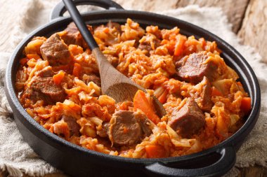 Baharatlı lahana, sığır eti, domates, havuç. Masadaki tavada yakın plan. yatay