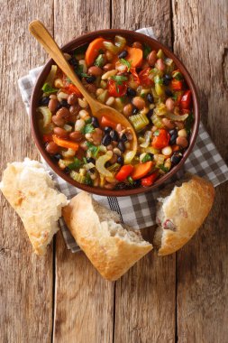 Üç fasulye kalın sıcak çorba. Sebzeli ve masada yakın plan ekmek servis ediliyor. Yukarıdan dikey üst görünüm