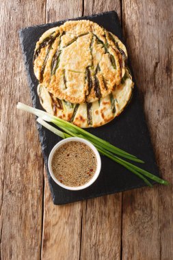 Masadaki tahtada yeşil soğanlı Pajeon Kore krepleri için temel tarif. Yukarıdan dikey üst görünüm