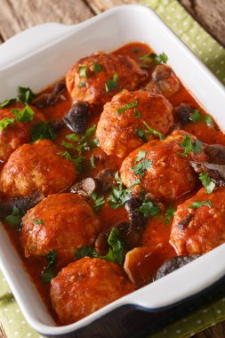 Domates soslu mantarlı köfteler. Masadaki tavada yakın plan. dikey