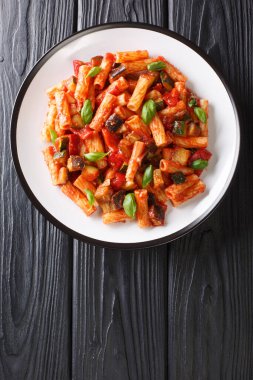 Patlıcan, kabak, biber ve fesleğen soslu Tortiglioni makarnası masanın üstünde. Yukarıdan dikey üst görünüm
