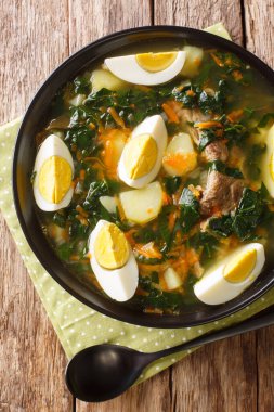 Et, sebze ve yumurtalı ıspanak çorbası masanın üstünde. Yukarıdan dikey üst görünüm