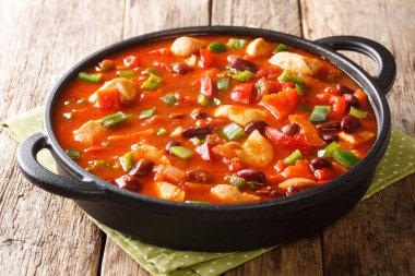 Homemade recipe for chicken stew with red beans in hot chili sauce close-up in a pan on the table. horizonta clipart