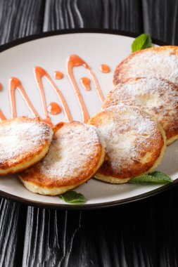 Geleneksel şurup servisi. Masadaki tabakta pudra şekeri ve böğürtlen reçeli ile servis ediliyor. dikey