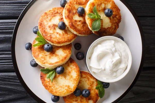 Yaban mersinli, naneli ve ekşi kremalı sıcak geleneksel şurup masanın üstünde. Yukarıdan yatay üst görünüm
