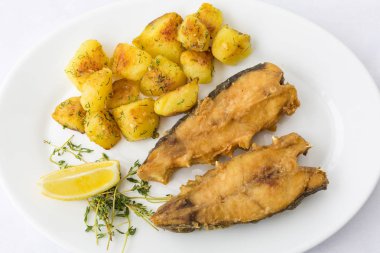 Kızarmış balık patates ile süslenmiş, restoranda en iyi görünümü kadar yakın