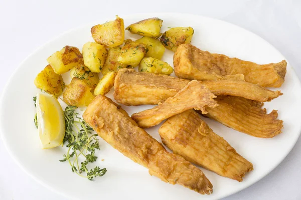 Смажена риба, прикрашена картоплею, крупним планом, вид зверху в ресторані — стокове фото