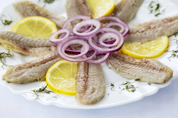 Marinated fish salad on white plate at restaurant