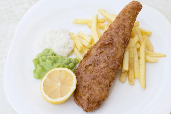 Британський традиційні риба із смаженою картоплею з пюре з гороху, татарським соусом на білий пластини. Вид зверху — стокове фото